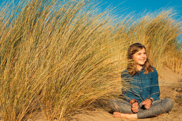 istock Child smiling amongst the sand dunes 869834148