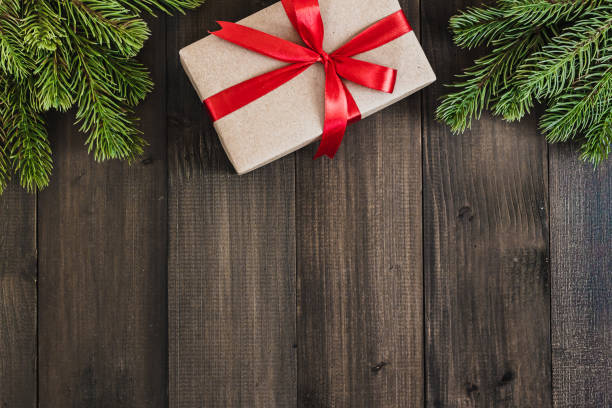 istock Christmas fir tree branches and gift box on dark rustic wooden background with copy space for text 869834806