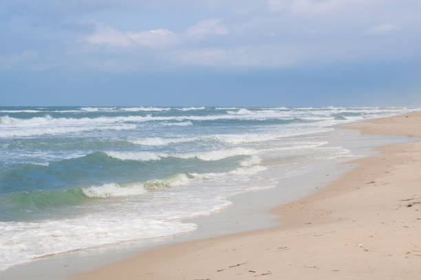 istock Sea coast waves rolling on sandy beach, stormy cloudy sunrise 869834898
