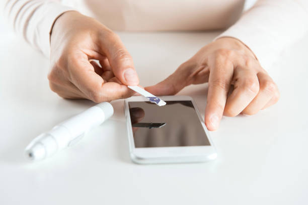 istock Woman with Smartphone Making Blood Test 869837572