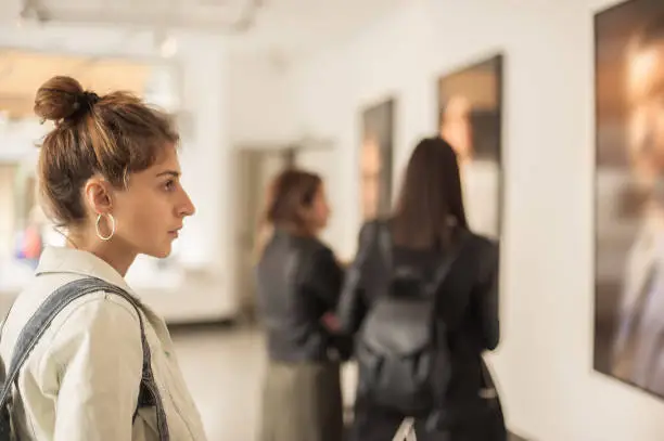 Photo of Group of woman looking at modern painting in art gallery