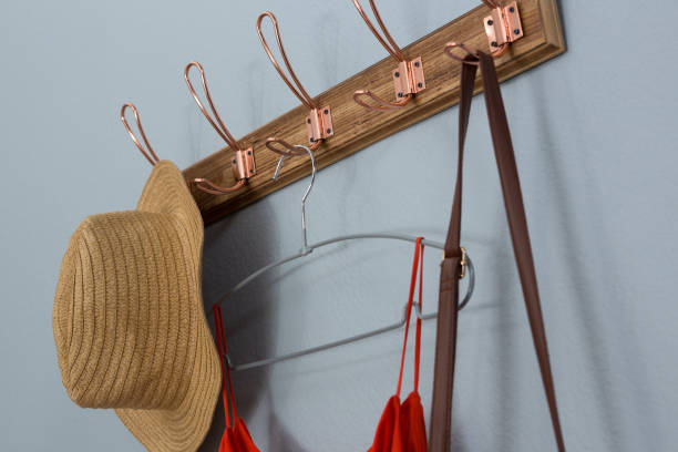 istock Straw hat, dress and bag hanging on wall 869841226