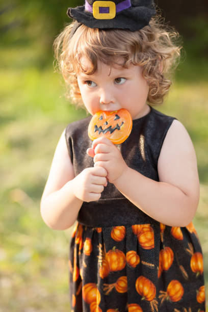 istock Little girl witch in black pointed hat and sunglasses. 869844828