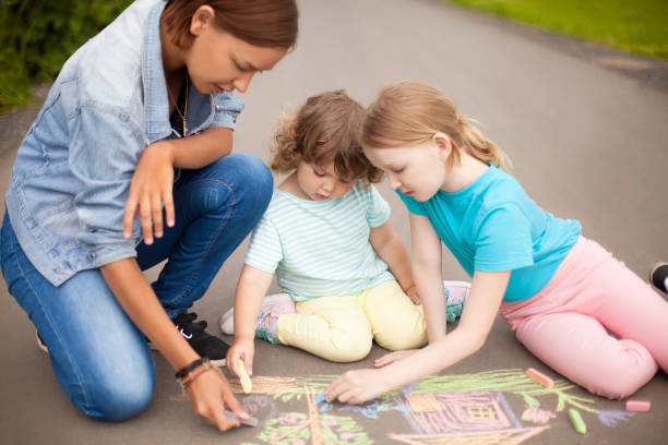 istock Babysitter or kindergarten concept. Children drawing with color chalk. 869845508