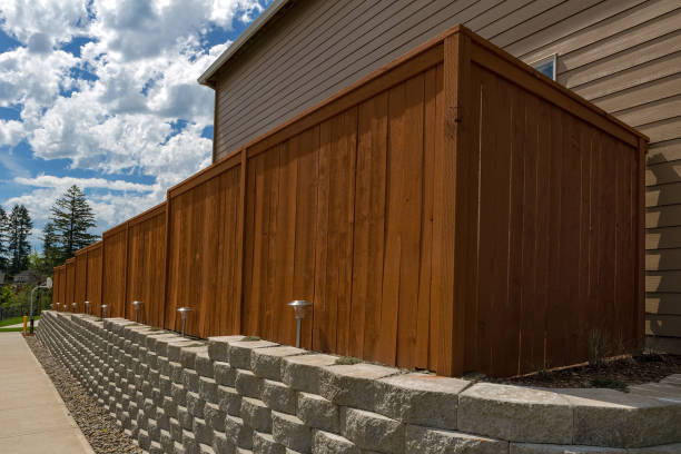 Impilamento in cemento recinzione in legno blocchi di pietra che mantiene il muro e illuminazione paesaggistica - foto stock