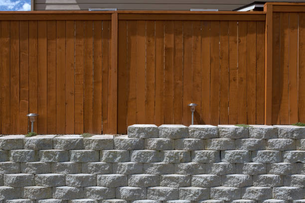 ウッド フェンス セメント スタック石擁壁と造園の照明のフロント ビュー - landscaped retaining wall wall stone ストックフォトと画像