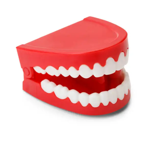 Red Plastic Wind Up Chatttering Teeth. Isolated on White Background.