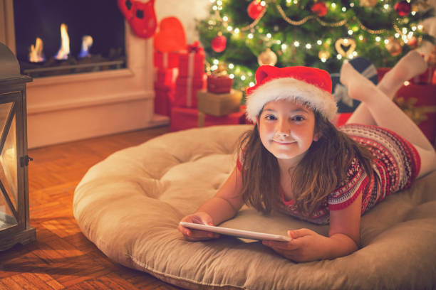 istock Beautiful little girl using digital tablet on Christmas night 869848820