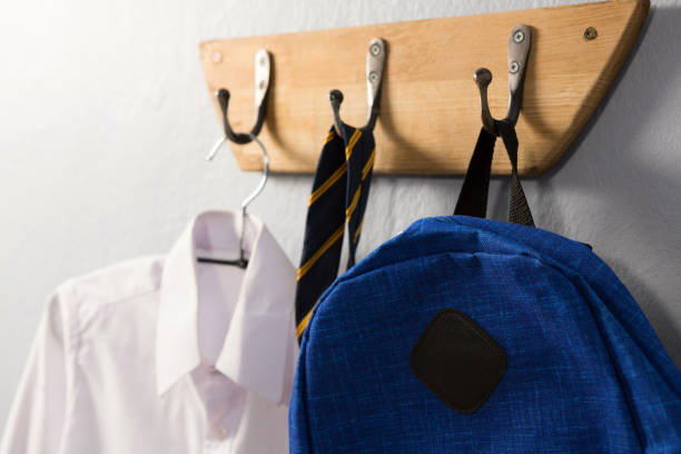 uniforme escolar y mochila de colgar en el gancho - uniforme de colegio fotografías e imágenes de stock