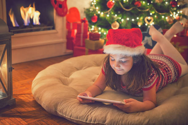 istock Beautiful little girl using digital tablet on Christmas night 869849230