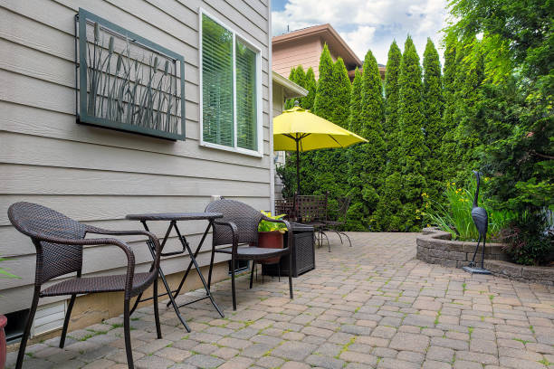 istock Bistro chairs and table on stone paver bricks patio in garden backyard with pond 869852032