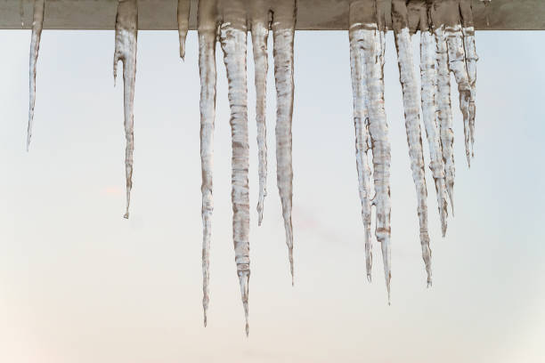 опасные сосульки на краю навеса крыши - melting ice icicle leaking стоковые фото и изображения