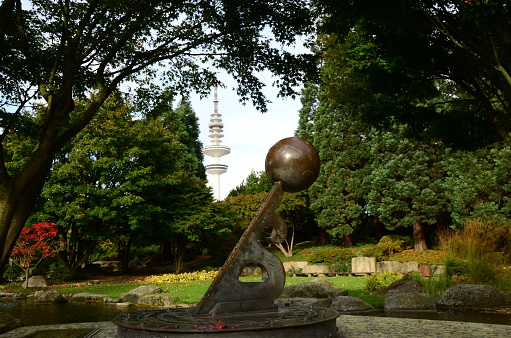 A view across a sundial and Japanese garden toward the radio tower in Hamburg