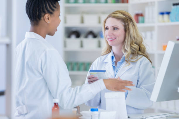 istock Pharmacist reviews a medication with pharmacy technician 869862216
