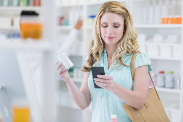 istock Woman uses smart phone while in pharmacy 869862256