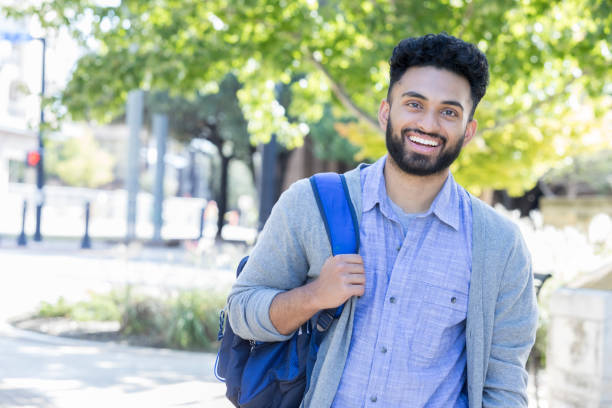 istock Young man smiles for camera on his university campus 869862542