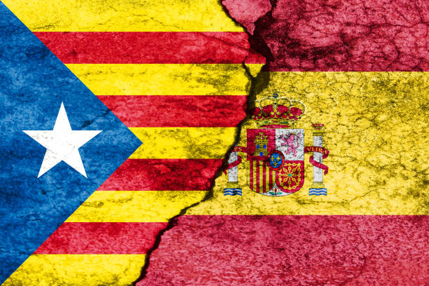 istock flags of spain and catalonia on broken wall 869863130