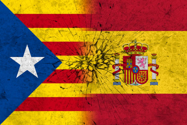istock flags of spain and catalonia on broken wall 869863158