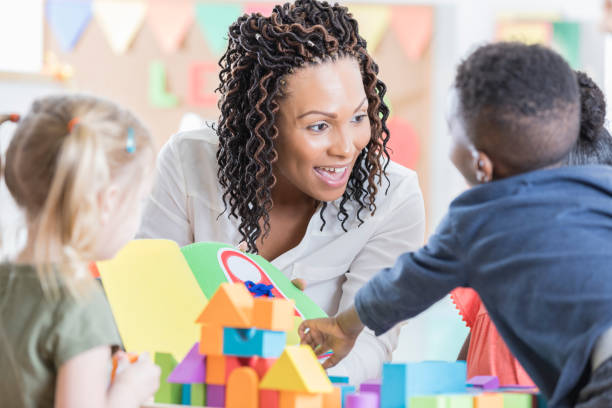 istock Friendly teacher enjoys playing with her preschool students 869863376