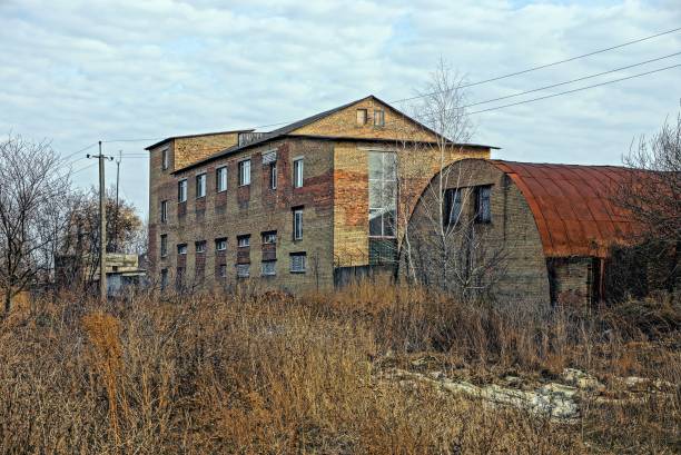istock Old brick industrial buildings in thickets of grass 869866330