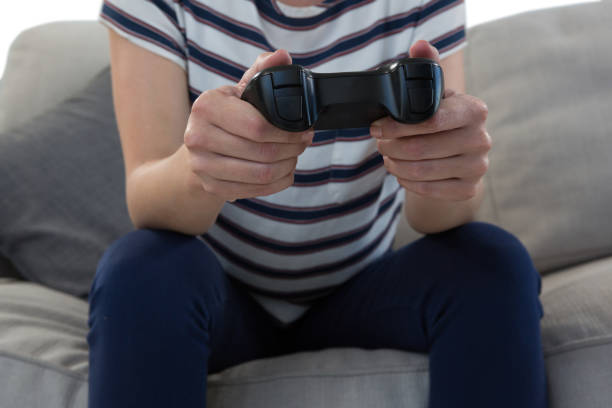 istock Woman playing video game on sofa 869866474