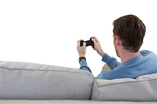 Rear view of man playing video game against white background