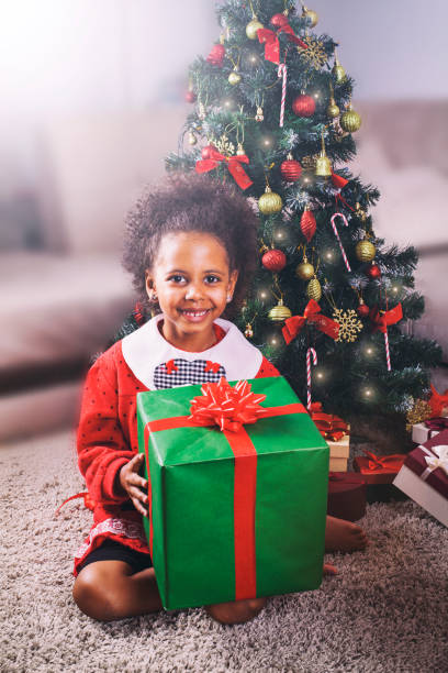 istock Excited African American child holding wrapped Christmas present 869879412
