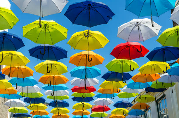 fondo de coloridos paraguas. sombrillas de colores en el cielo soleado. decoración de la calle. - rainbow umbrella descriptive color multi colored fotografías e imágenes de stock