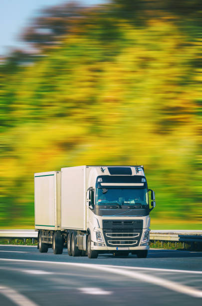 istock White truck driving on multiple highway at autumn 869892182