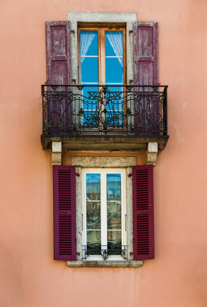 istock Balcony and windows with open shutters on classic apartment building 869893604