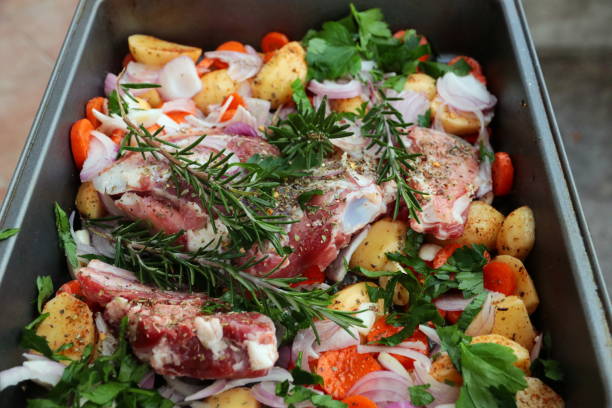 rosmary、ニンニク野菜焙煎の準備とヤギの肉 - lamb chop shank cooked ストックフォトと画像