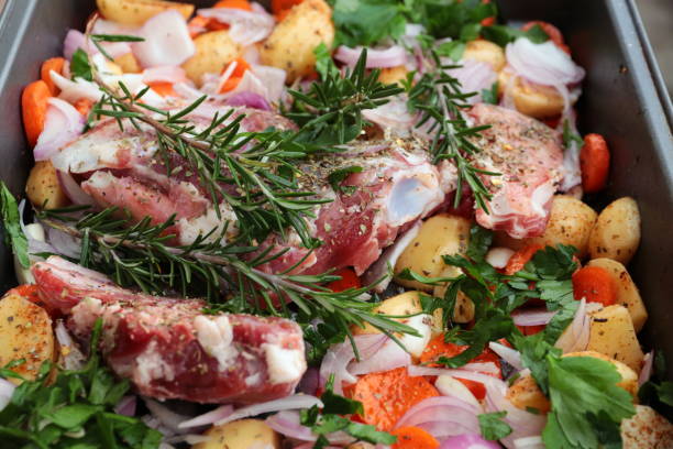 rosmary、ニンニク野菜焙煎の準備とヤギの肉 - lamb chop shank cooked ストックフォトと画像