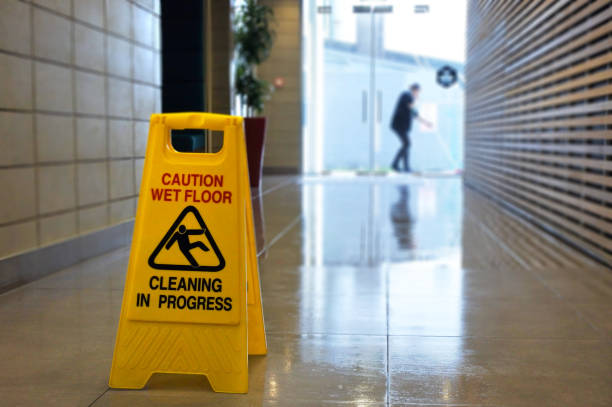 segnale di avvertimento e simbolo della superficie del pavimento scivoloso su un pavimento bagnato - floor wet slippery danger foto e immagini stock