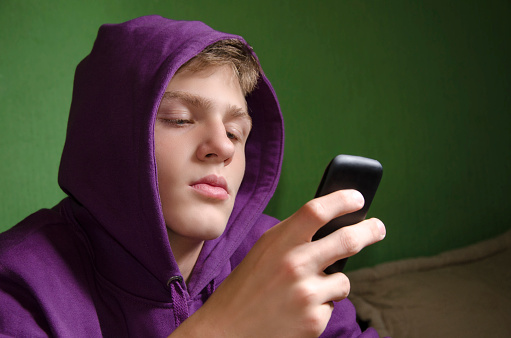 Sad depressed kid waiting for text message reply