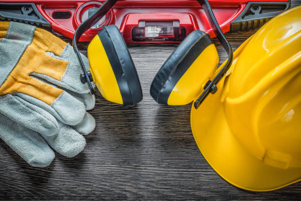 istock Construction level protective gloves hard hat earmuffs on wooden 869905646