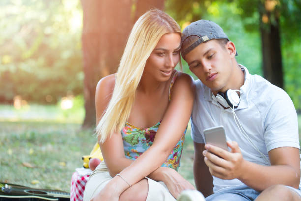 istock Cute guy and girl using smartphone 869906120