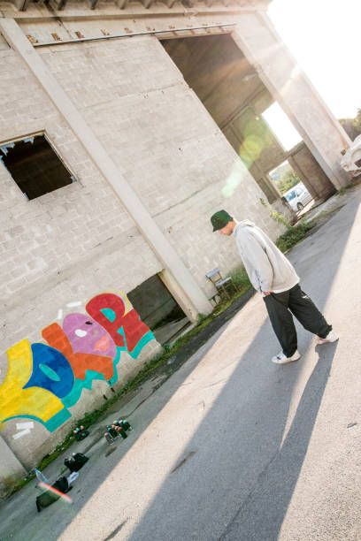 grafiteiro andando na parede - graffiti paintings men walking - fotografias e filmes do acervo