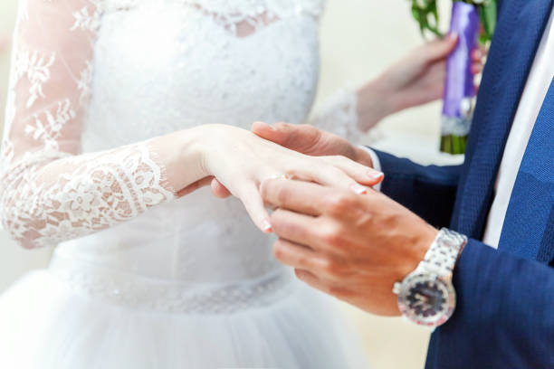 istock the groom wears a ring on the bride's 869915070