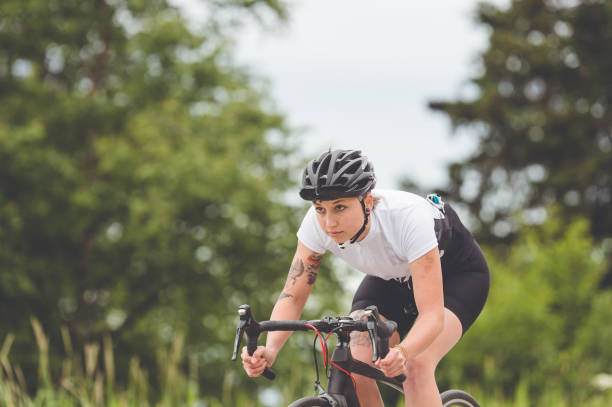 istock Female cyclist rides along a rural highway 869915686