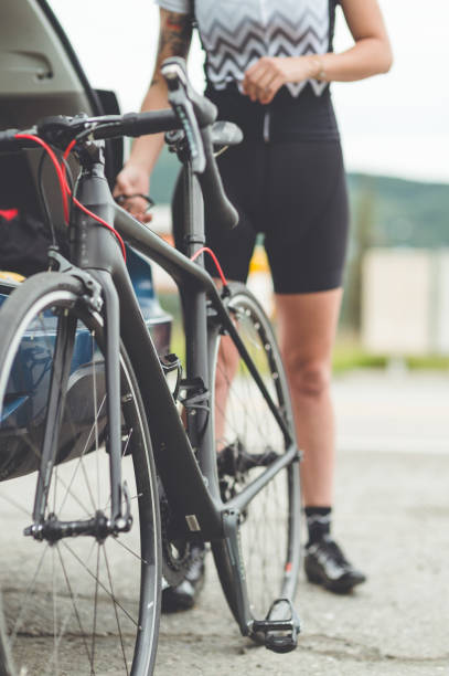 istock Bicyle leaning against car while cyclist gets ready to rideq 869915688