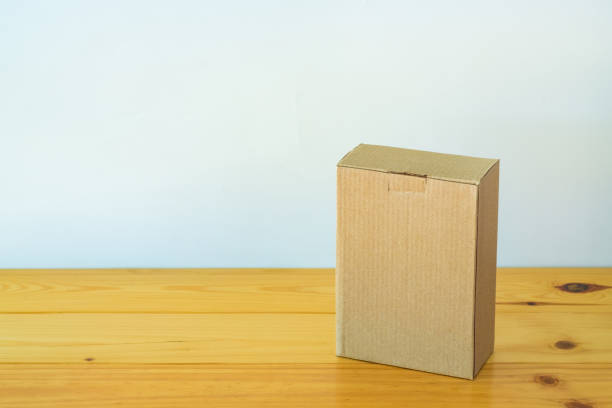 istock Empty closed brown cardboard box for mock up on the wooden table with copy space. 869926604