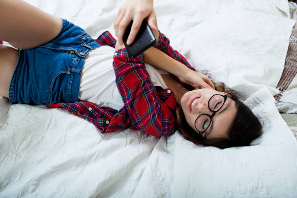 istock girl lying on the bed using a smartphone 869936170