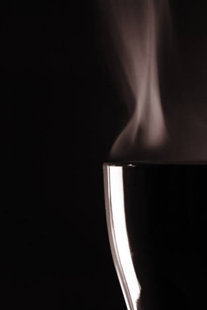 istock Cup of tea with steam pattern on a dark black background. 869950966