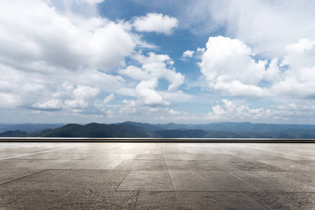 istock empty marble floor with green hill in cloud sky 869956242