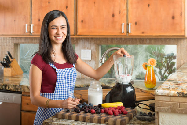 istock Hispanic Women In The Kitchen Making A Smoothie 869956598