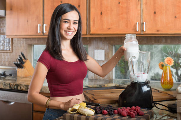 istock Hispanic Women In The Kitchen Making A Smoothie 869960346