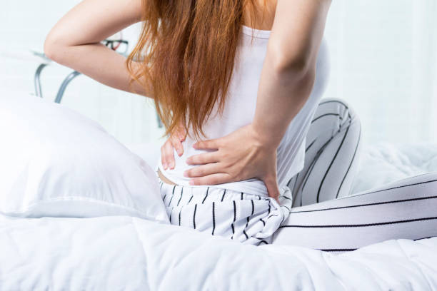 istock Beautiful young woman suffering from backache  on bed 869970178