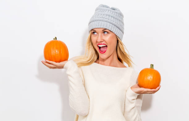 istock Young woman holding pumpkins 869973680