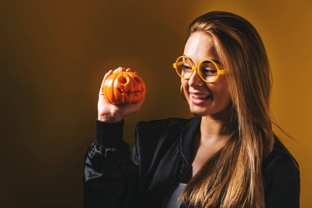 giovane donna che tiene in mano una zucca - pumpkin small orange holiday foto e immagini stock