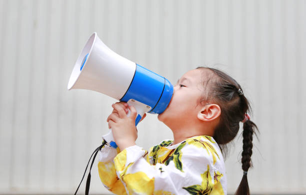 istock Asian Kid girl shouting through megaphone. Communication concept. 869974386